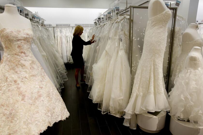 LOS ANGELES, CA. - JANUARY 20, 2014: Store manager Sonni Sanders (CQ) looks for gowns for customers to try on at David's Bridal which opened its first upscale boutique in the country in Los Angeles on West Pico Boulevard in Los Angeles on January 20, 2014. (Anne Cusack/Los Angeles Times)