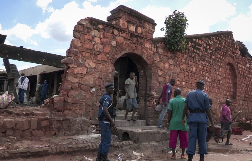 In this image made from video, security forces and others gather outside the scene of a fire at a prison in Gitega, Burundi Tuesday, Dec. 7, 2021. Burundi's government says 38 prisoners have been killed in the fire Tuesday morning at the overcrowded prison, with more than 60 other people injured and the death toll could rise. (AP Photo)