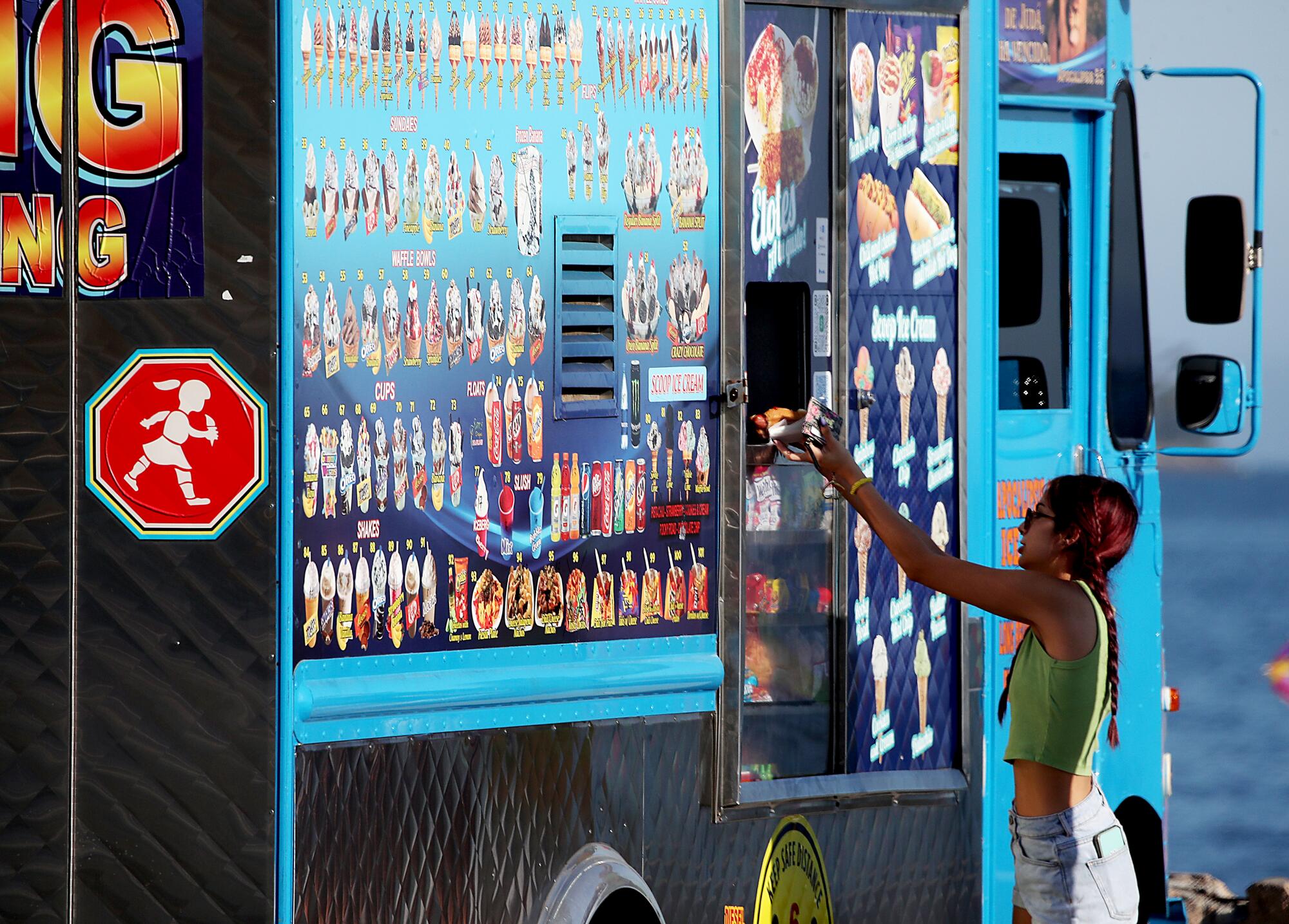 A beachgoer purchases refreshments from a food truck at Junipero Beach in Long Beach