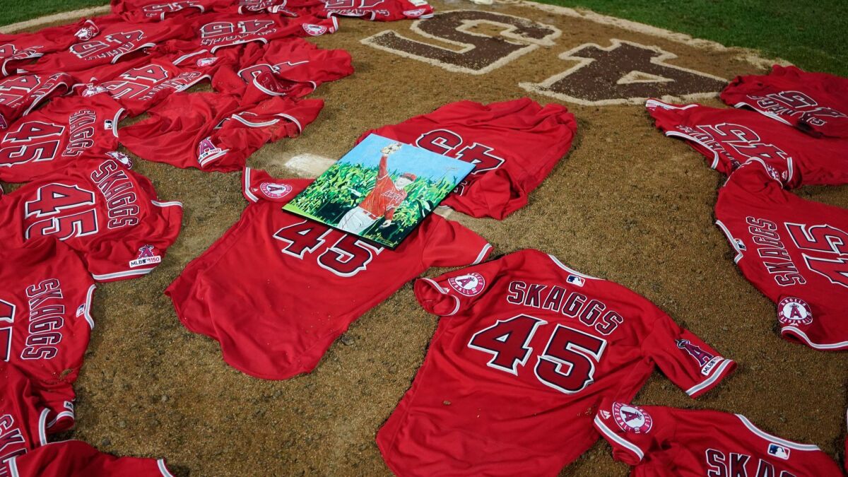 A portrait of the late Angels pitcher Tyler Skaggs sits atop the jerseys of the Angels that were laid atop the pitchers mound after the Angels defeated the Seattle Mariners on Friday at Angel Stadium.