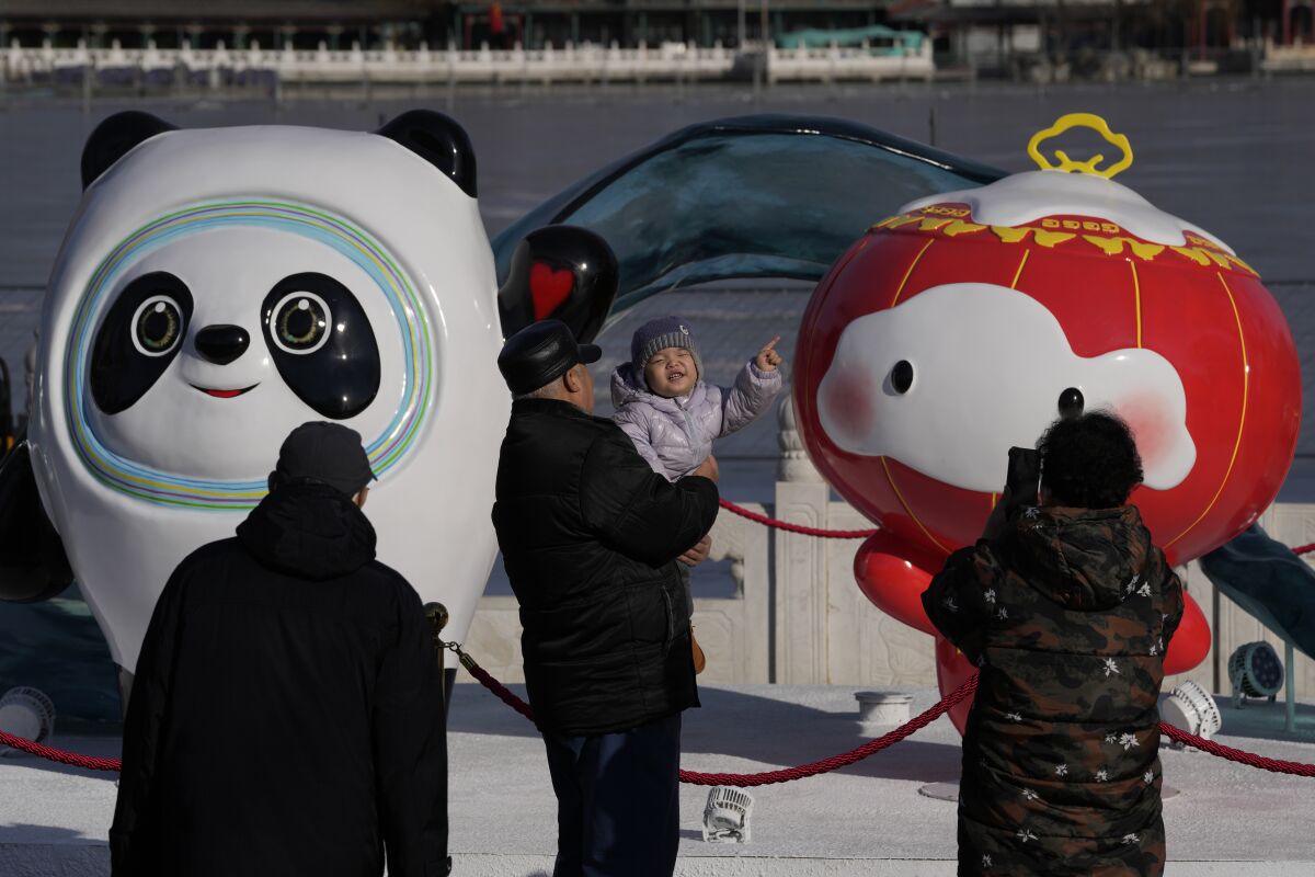 A child reacts to the Winter Olympics mascots.