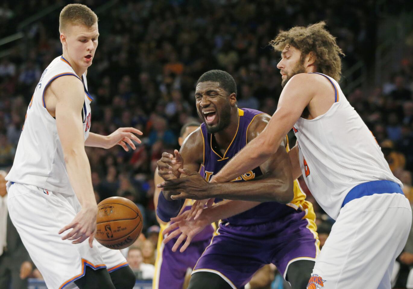 Lakers center Roy Hibbert loses control of the ball as he's defended by Knicks forward Kristaps Porzingis, left, and center Robin Lopez in the second half Sunday.