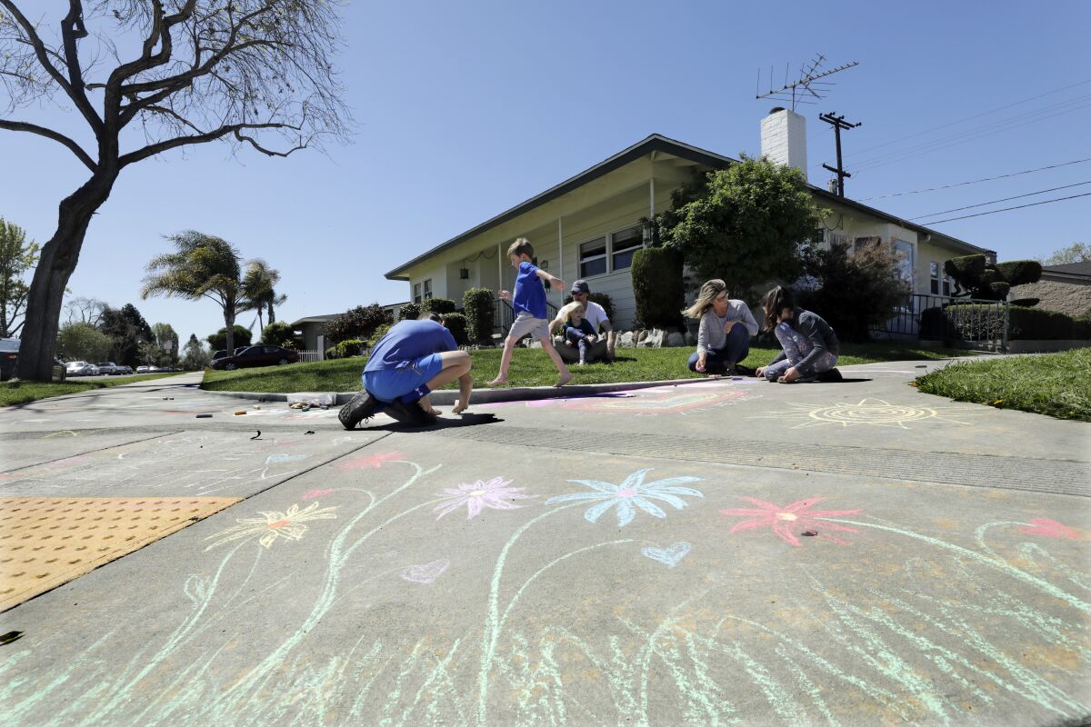 Adam Trafas and Lisa Hildreth are juggling working from home and home-schooling their four children. One thing they do, along with their neighbors, is let their kids Logan Trafas, left; Eli Trafas; Libby Trafas, and Dylan Rose Trafas, far right, do chalk drawings on the sidewalk, following a different theme every week.