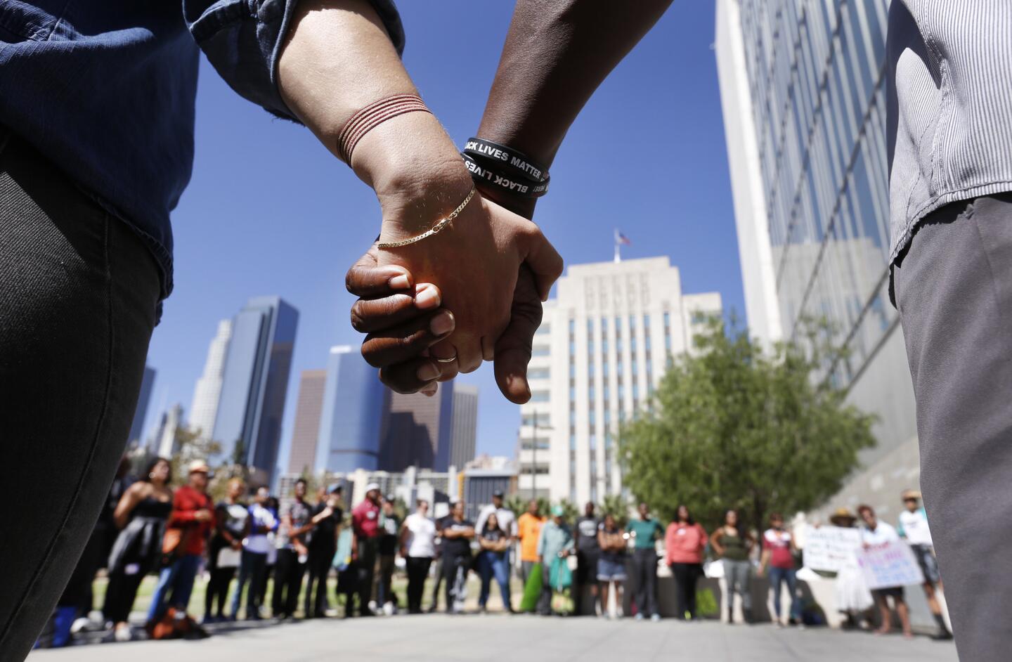 Pastor Cue Jn-Marie, right, and Taylor Fisher hold hands in a prayer circle after demonstrators left the Los Angeles Police Commission meeting, which was halted because of public outbursts.