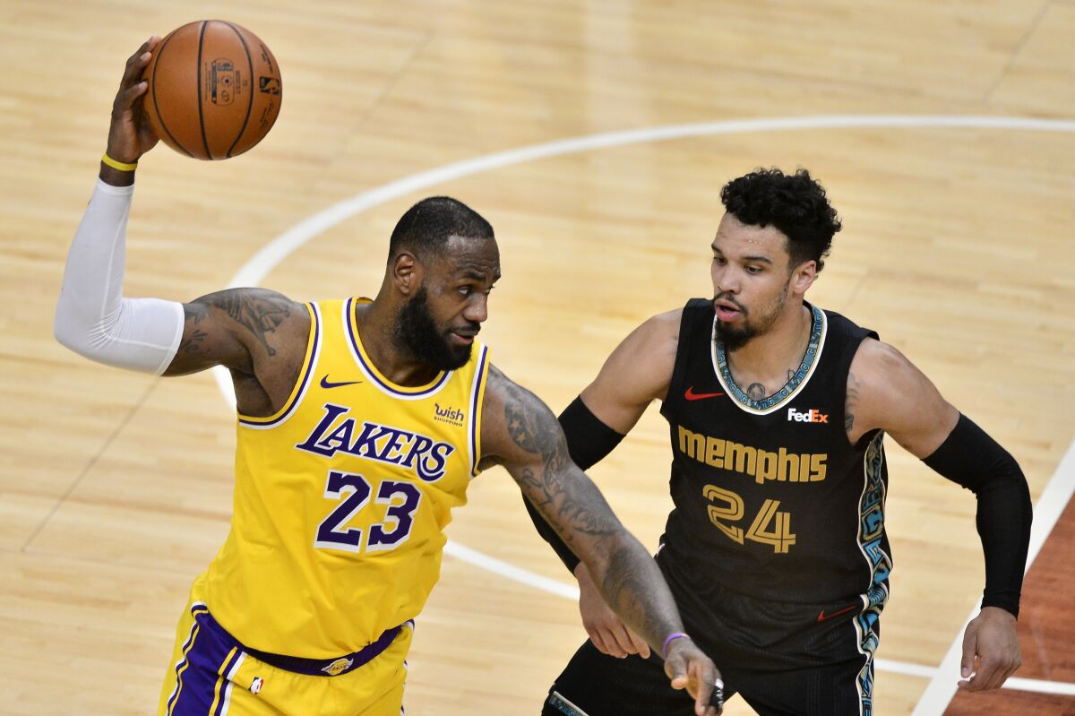 Lakers forward LeBron James catches a pass against Grizzlies guard Dillon Brooks during a game Jan. 5, 2021, in Memphis.