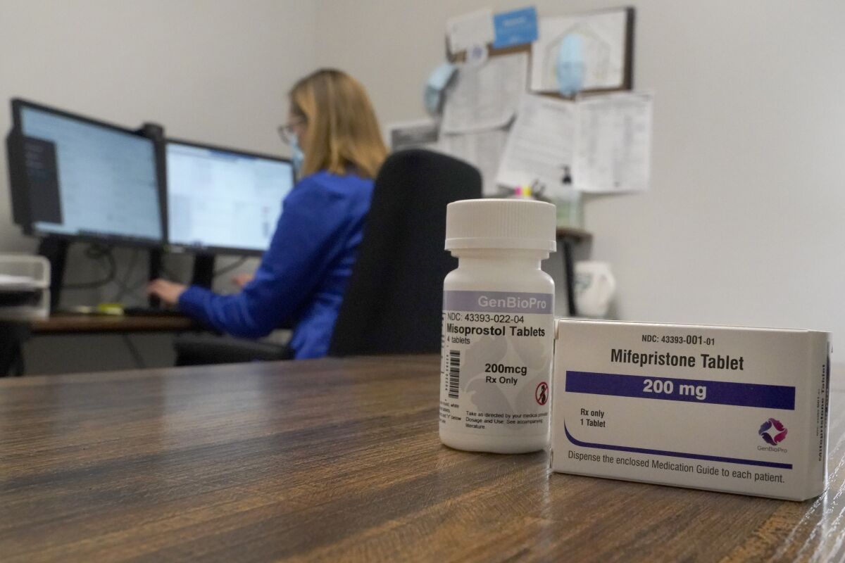 A Nurse Practitioner works in an office at a Planned Parenthood clinic where she confers via teleconference with patients seeking self-managed abortions as containers of the medication used to end an early pregnancy sits on a table nearby Friday, Oct. 29, 2021, in Fairview Heights, Ill. Women with unwanted pregnancies are increasingly considering getting abortion pills by mail. (AP Photo/Jeff Roberson)
