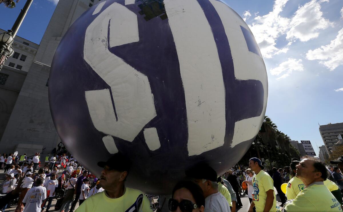 At a rally outside Los Angeles City Hall, workers press their demand for a minimum wage of $15 per hour.