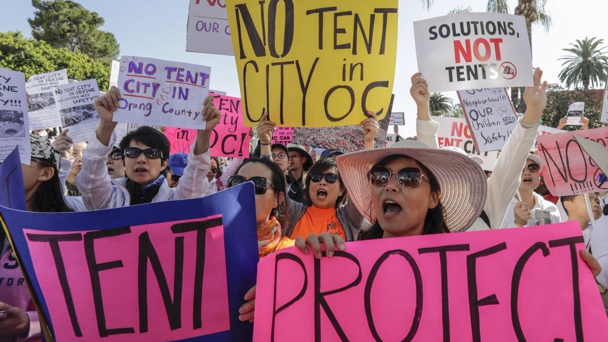 Residents of Irvine, Huntington Beach and Laguna Niguel protest last week as the Orange County Board of Supervisors discussed possible locations for temporary homeless shelters. The board ultimately scrapped a plan for sites in those cities.