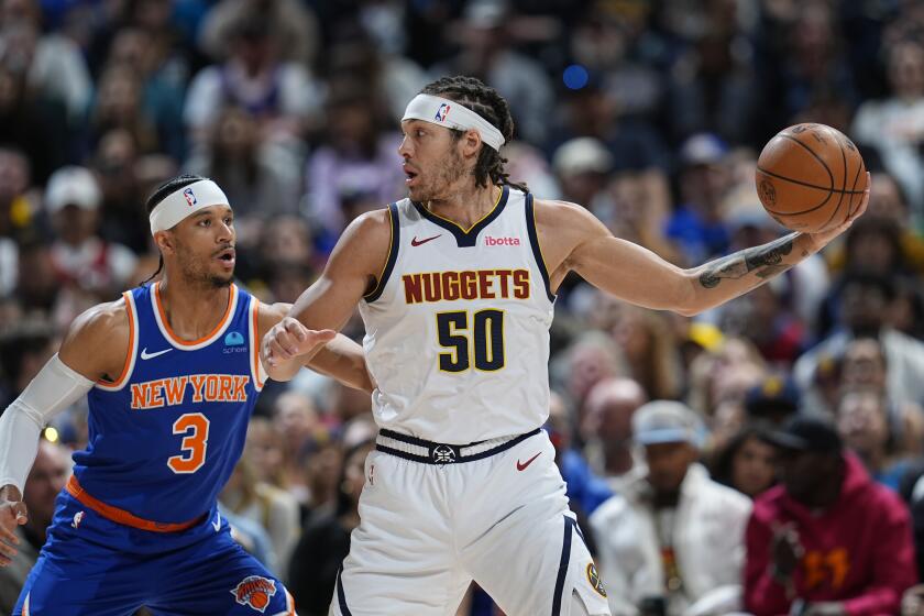 El alero de los Nuggets de Denver Aaron Gordon pasa el balón superando al base de los Knicks de Nueva York Josh Hart en el encuentro de la NBA del jueves 21 de marzo del 2024 (AP Foto/David Zalubowski)