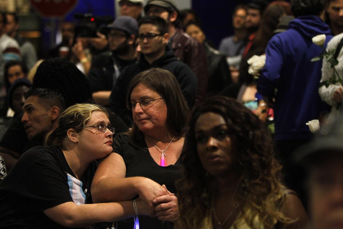 Jennifer Doyle, left, embraces her girlfriend Trisha Pedroza outside the West Hollywood Library during the reading of names of transgender people beaten and killed in hate crimes during a Transgender Day of Remembrance.