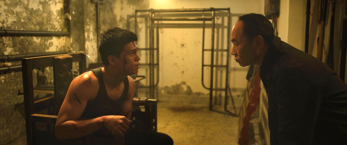 A man interrogates a bleeding man in the movie “Unsilenced.”