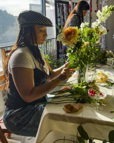 A person makes a flower arrangement at the Bubbles & Blooms floral workshop.