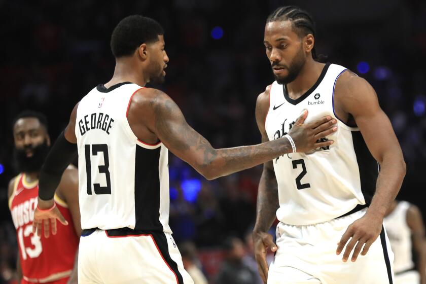 Kawhi Leonard #2 is congratulated by Paul George #13 of the Los Angeles Clippers during a game against the Houston Rockets