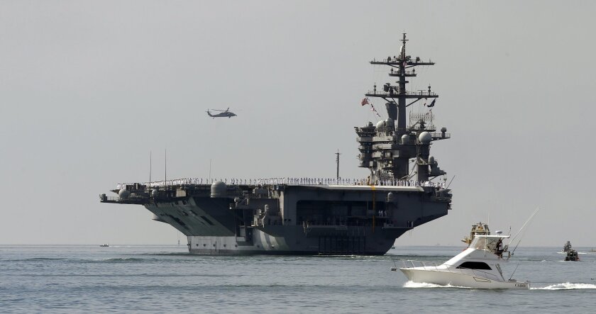 FILE-This Friday, Aug. 22, 2014 file photo the aircraft carrier USS Carl Vinson sails out of San Diego Harbor leaving for a nine month deployment in San Diego. (AP Photo/Lenny Ignelzi,File)