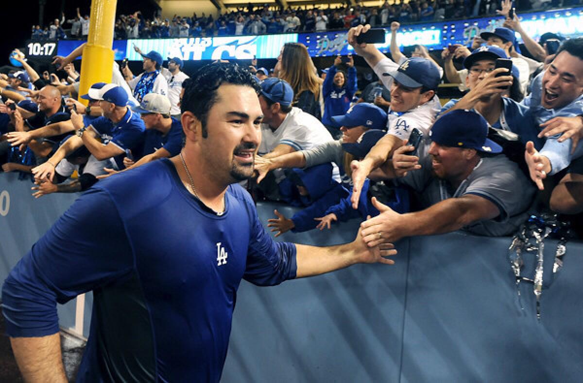 Dodgers first baseman Adrian Gonzalez celebrates with fans after defeating the Braves in Game 4 of the National League division series.