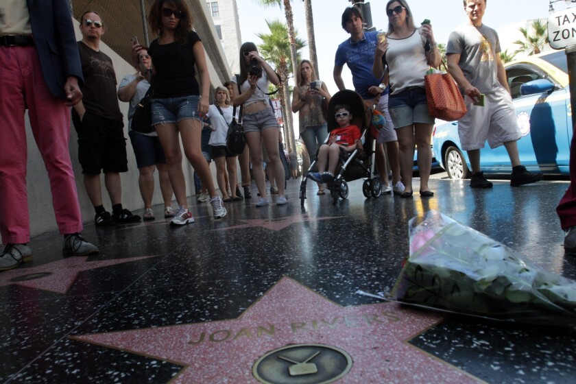 Tourists stop to take pictures on the Hollywood Walk of Fame. 