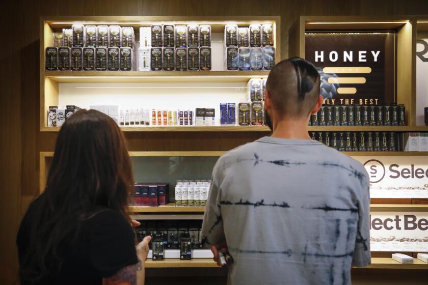 Tina Glen, left, and Nick Isordia, right, look at some of the the vaping products at March and Ash, a cannabis dispensary in Mission Valley, October 10, 2019, in San Diego, California.