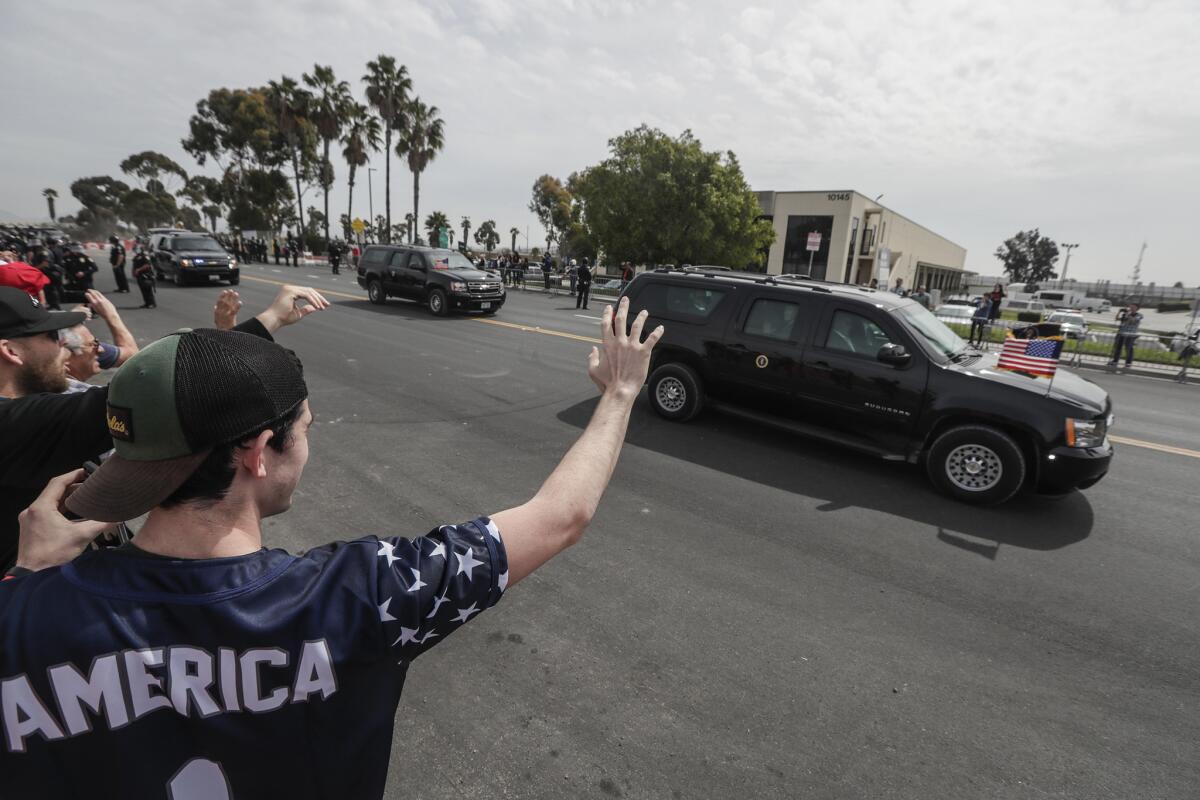Supporters wave as President Trump's motorcade passes near the border in San Diego earlier this year.