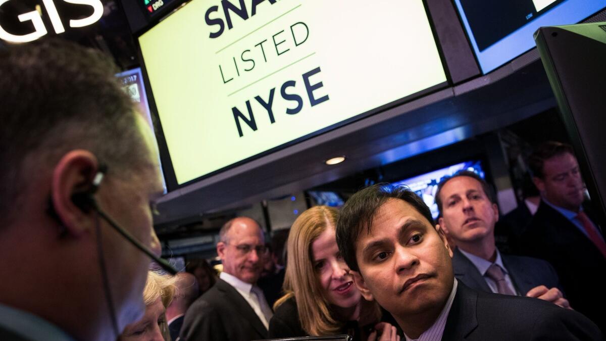 Imran Khan, right, then chief strategy officer of Snap Inc., waits for shares to open for trading on the floor of the New York Stock Exchange on March 2, 2017.