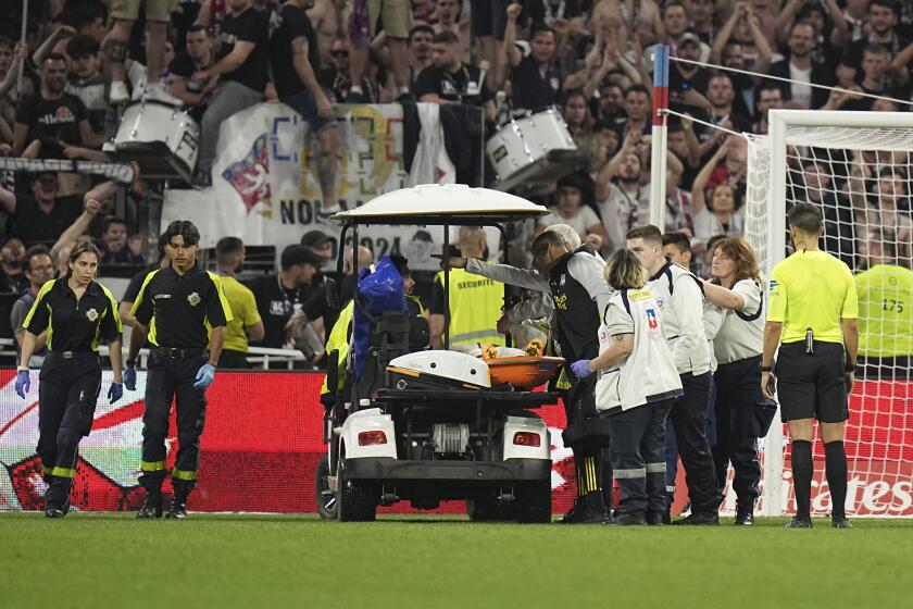 Lyon's Alexandre Lacazette is carried injured out of the pitch by medical staff during a French League One soccer match between Lyon and Brest at the Groupama stadium, outside Lyon, France, Sunday, April 14, 2024. (AP Photo/Laurent Cipriani)