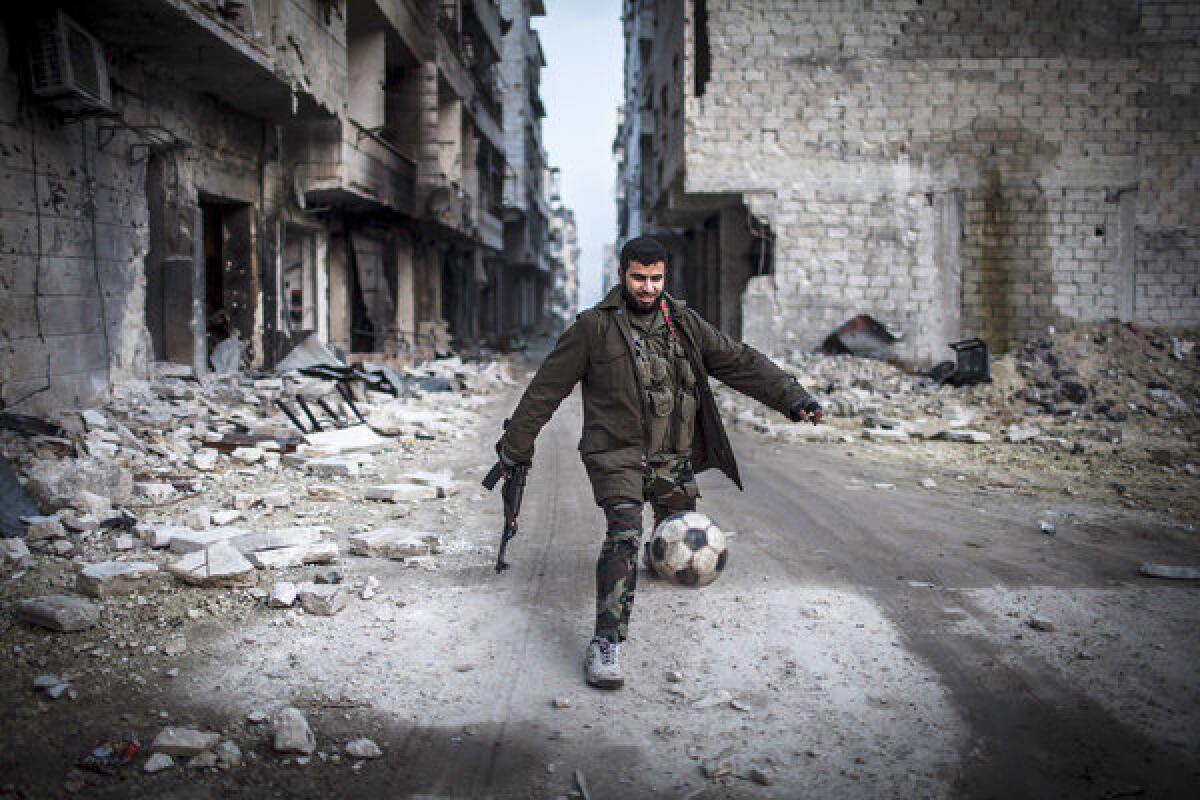 A Syrian rebel kicks a soccer ball in the Saif al-Dawlah neighborhood of Aleppo. The United Nations estimated Wednesday that more than 60,000 people have been killed in Syria's 21-month-old uprising.