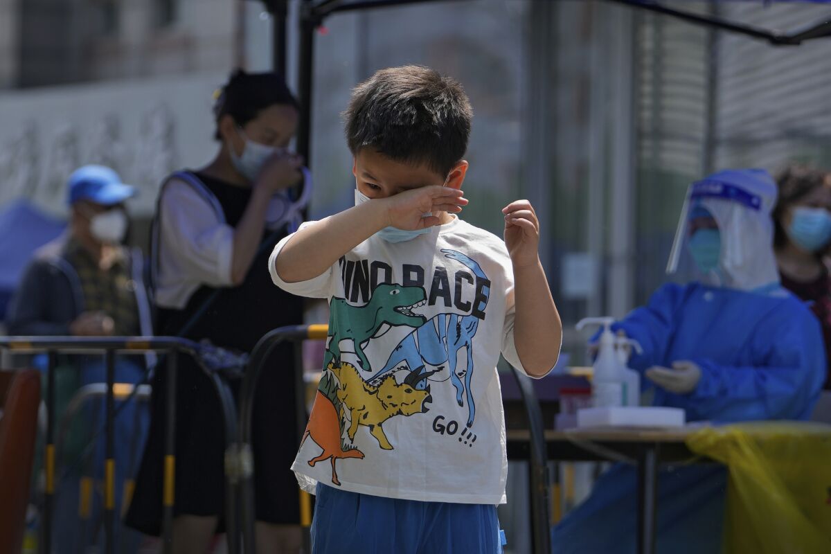 A child rubs his eyes after getting a COVID-19 test during a public testing on Tuesday, May 17, 2022, in Beijing. (AP Photo/Andy Wong)
