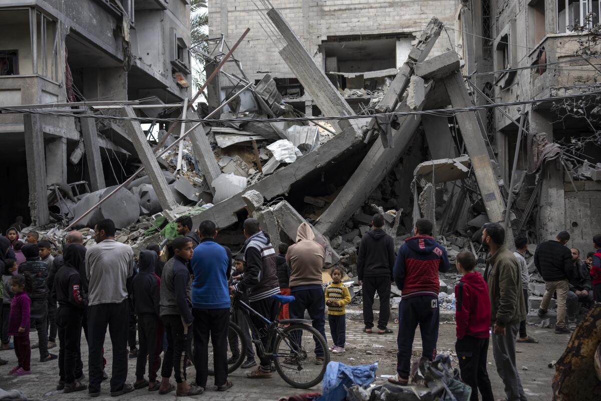Palestinians inspect the damage of residential buildings.