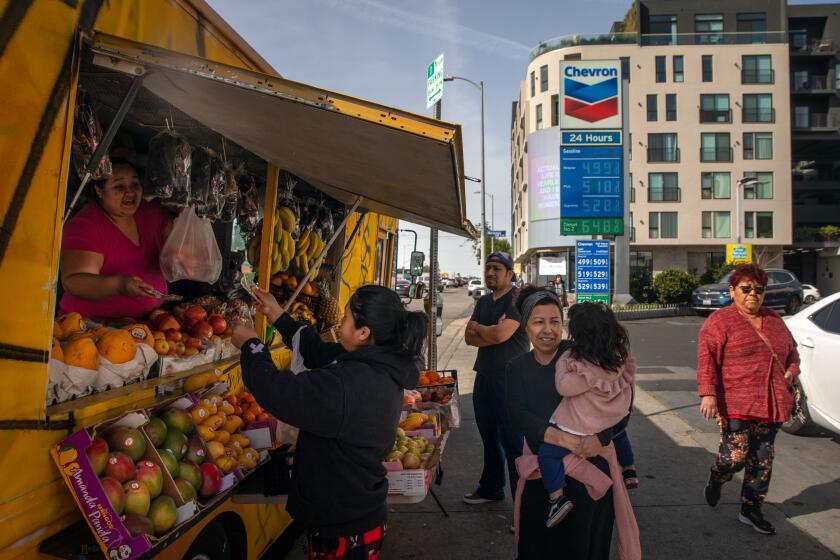 Los Angeles, CA - February 16: Resident shop at a fruits and vegetables vendor at a gas station where gas prices going up. Gas price went $.10 up after this photo was shot at 3800 Block of West 3rd. Street on Thursday, Feb. 16, 2023 in Los Angeles, CA. (Irfan Khan / Los Angeles Times)