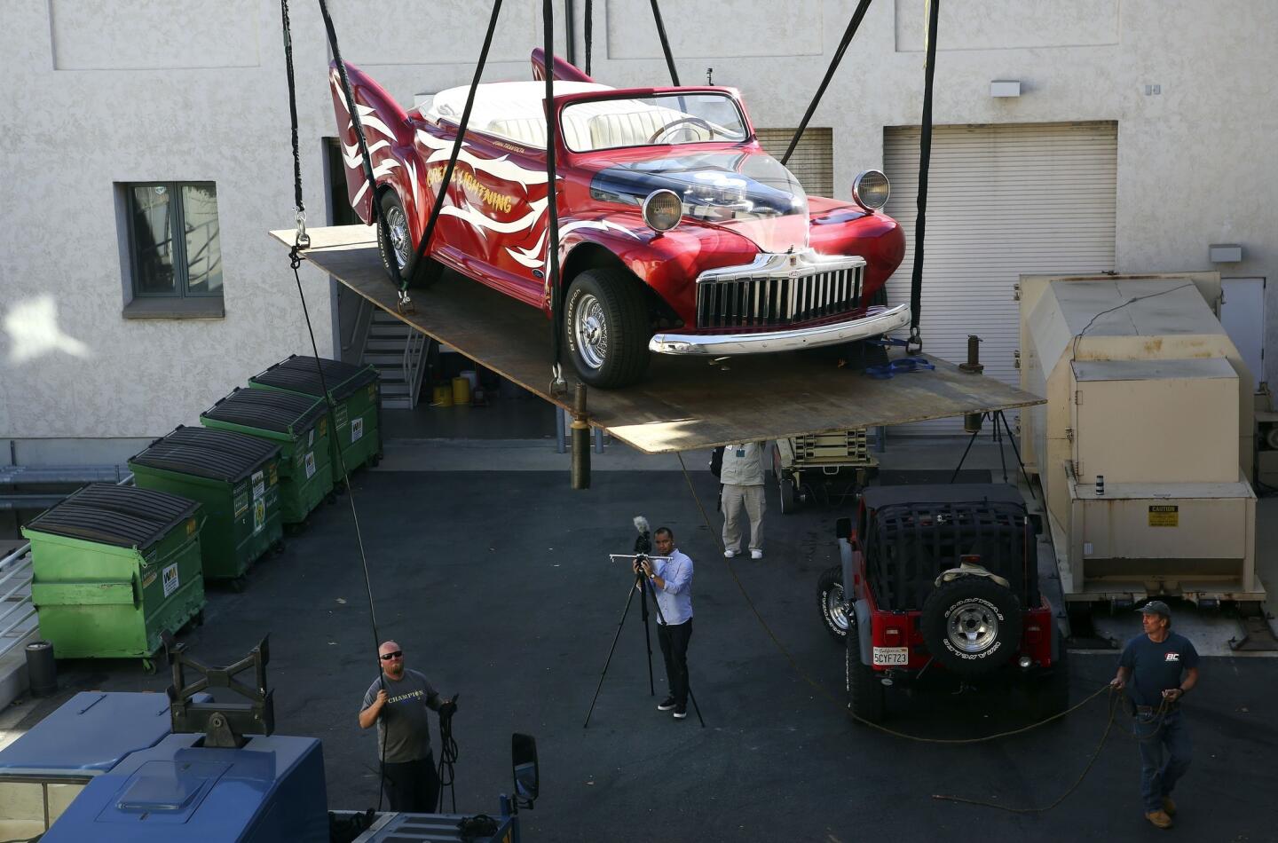 The 1946 custom Ford used by John Travolta and Olivia Newton-John in the 1978 movie "Grease" is hoisted by a crane to the second-story gallery at the Ronald Reagan Presidential Library in Simi Valley.