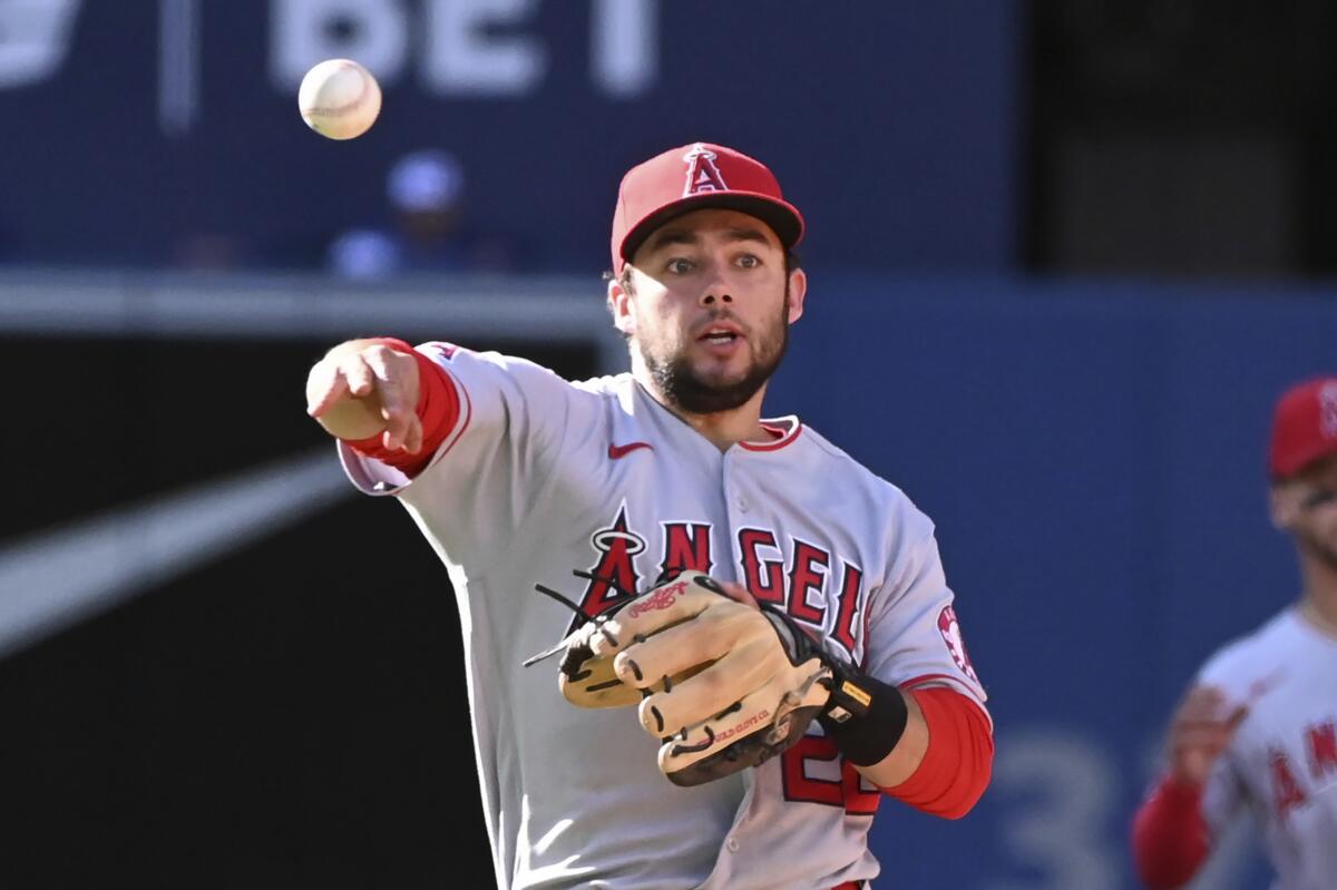 Angels second baseman David Fletcher throws to first base to retire the Blue Jays' Santiago Espinal on Aug. 27, 2022.
