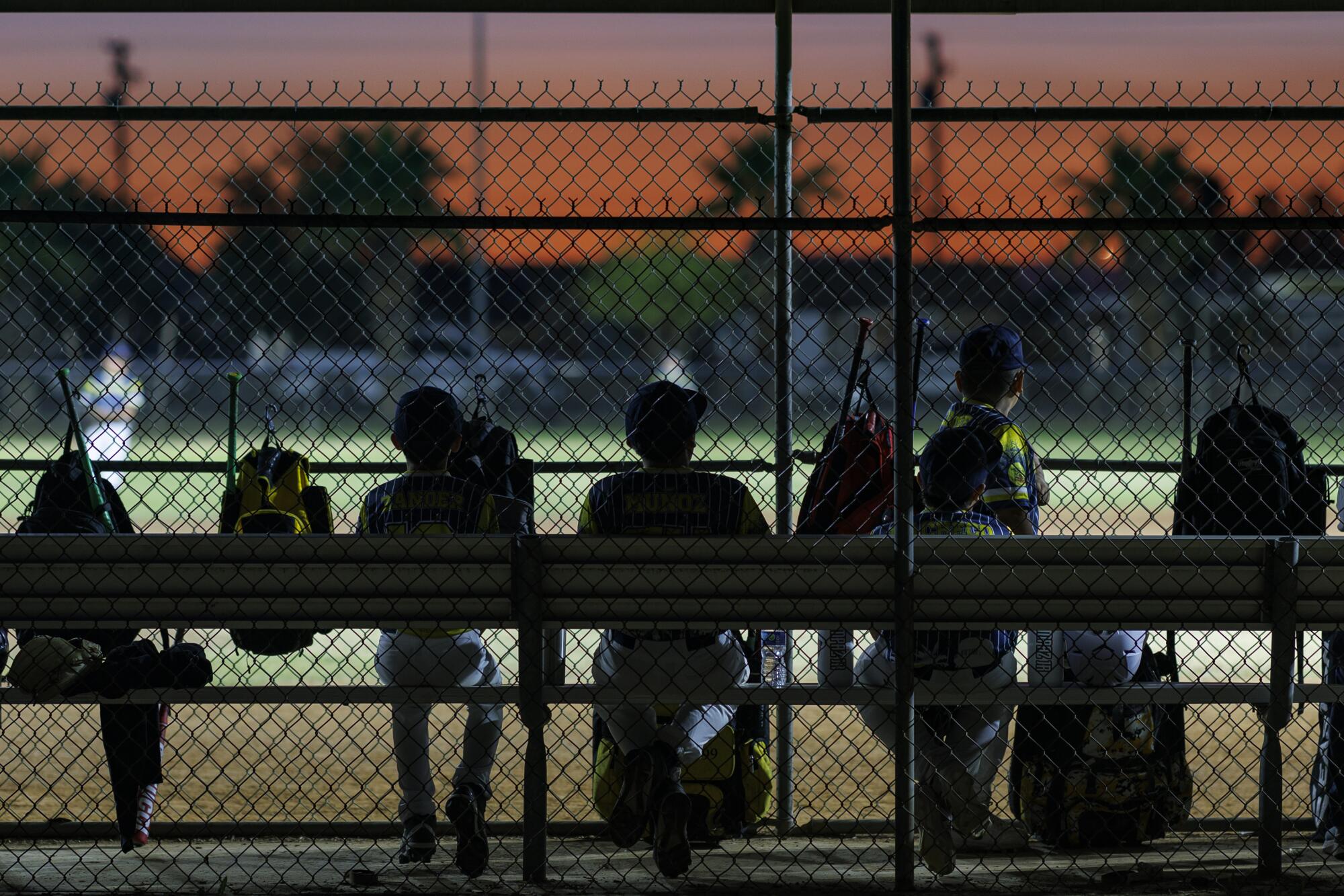 The colorful dusk sky hovers over a Little League baseball game at Freddie White Park in Imperial.