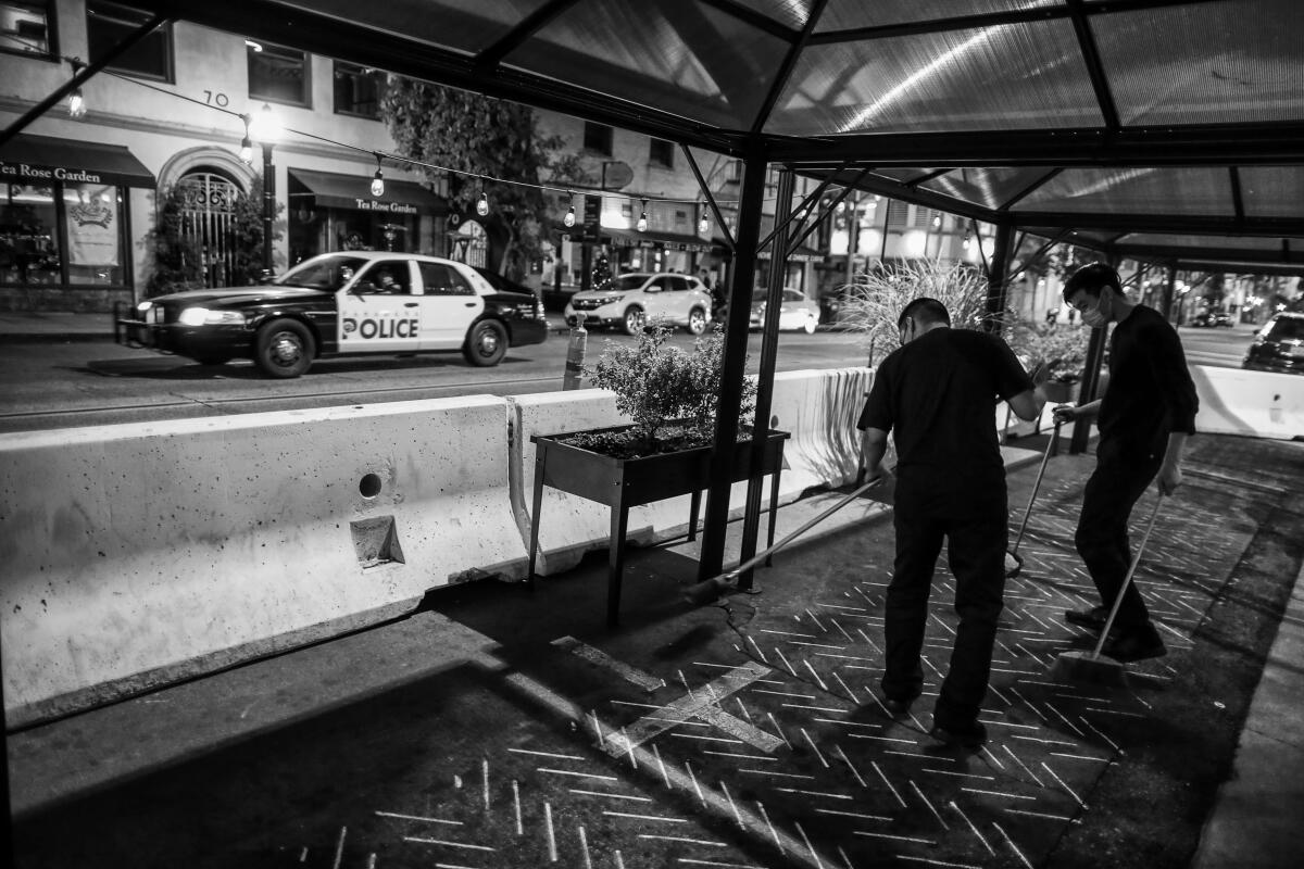 Pasadena police patrol Raymond Avenue as restaurants scramble to comply with a state-mandated 10 p.m. curfew.