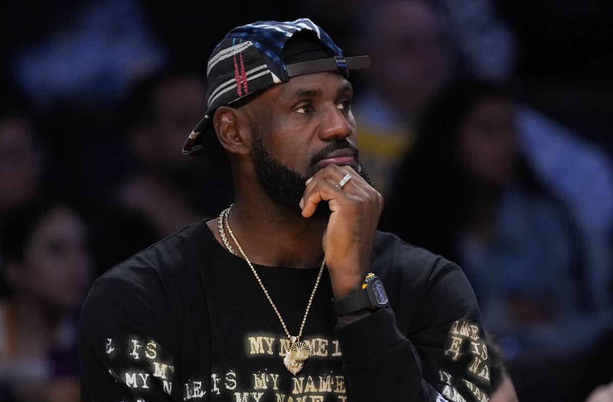 Lakers takeaways: What we discovered from the workforce's five-game highway journey 3 Lebron James wears a backwards cap and holds his left hand to his chin as sits on the Lakers bench.