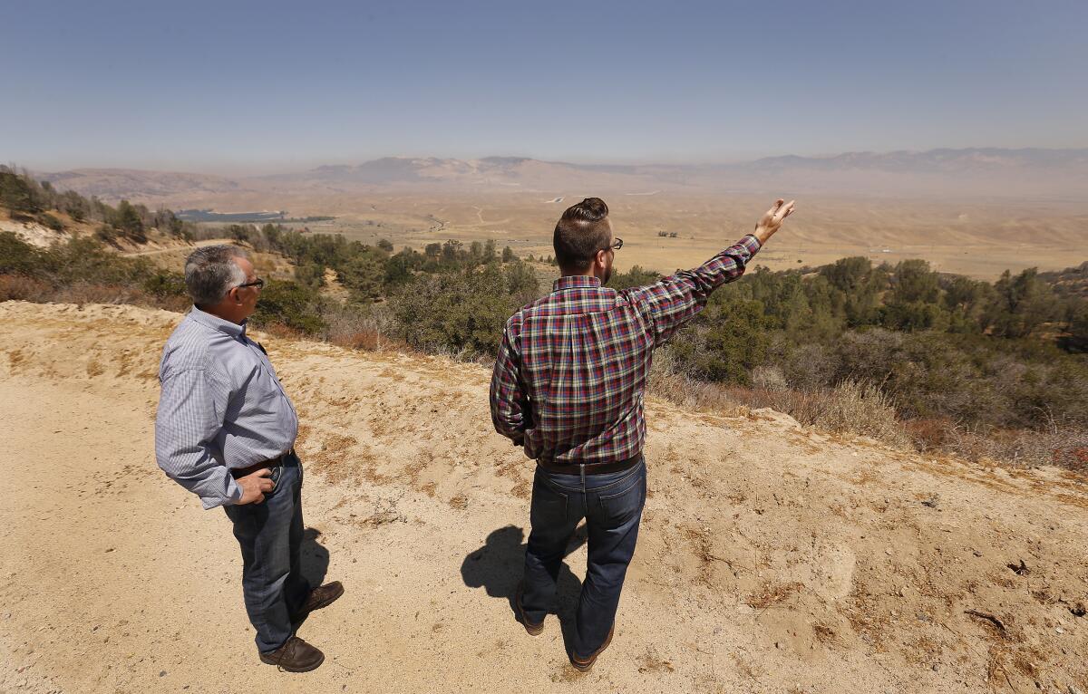 Tejon Ranch Co. executives Nathan Keith, right, and Greg Medeiros stand on a bluff overlooking Centennial development site
