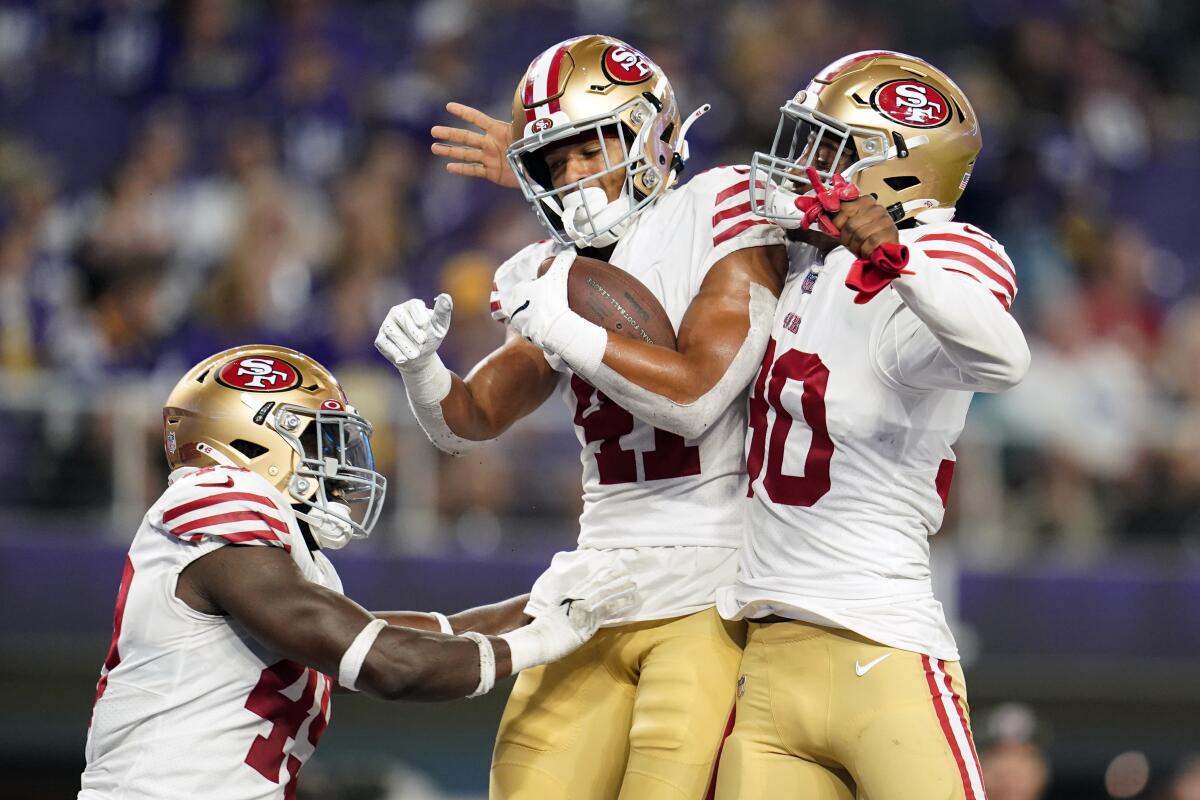 San Francisco 49ers defensive back Tayler Hawkins, center, celebrates with teammates linebacker Segun Olubi, left, and safety George Odum, right, after intercepting a pass during the second half of a preseason NFL football game against the Minnesota Vikings, Saturday, Aug. 20, 2022, in Minneapolis. (AP Photo/Abbie Parr)