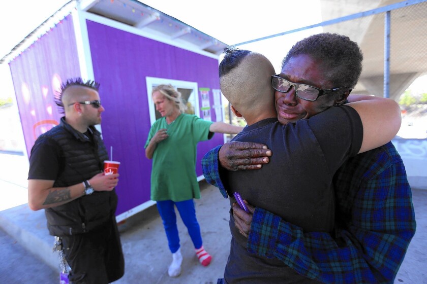 Julia Briggs Cannon, right, gets a hug from Marisol Viera as Elvis Summers prepares to haul away the shelter he built for Cannon. Summers was acting before city workers could seize the structure.