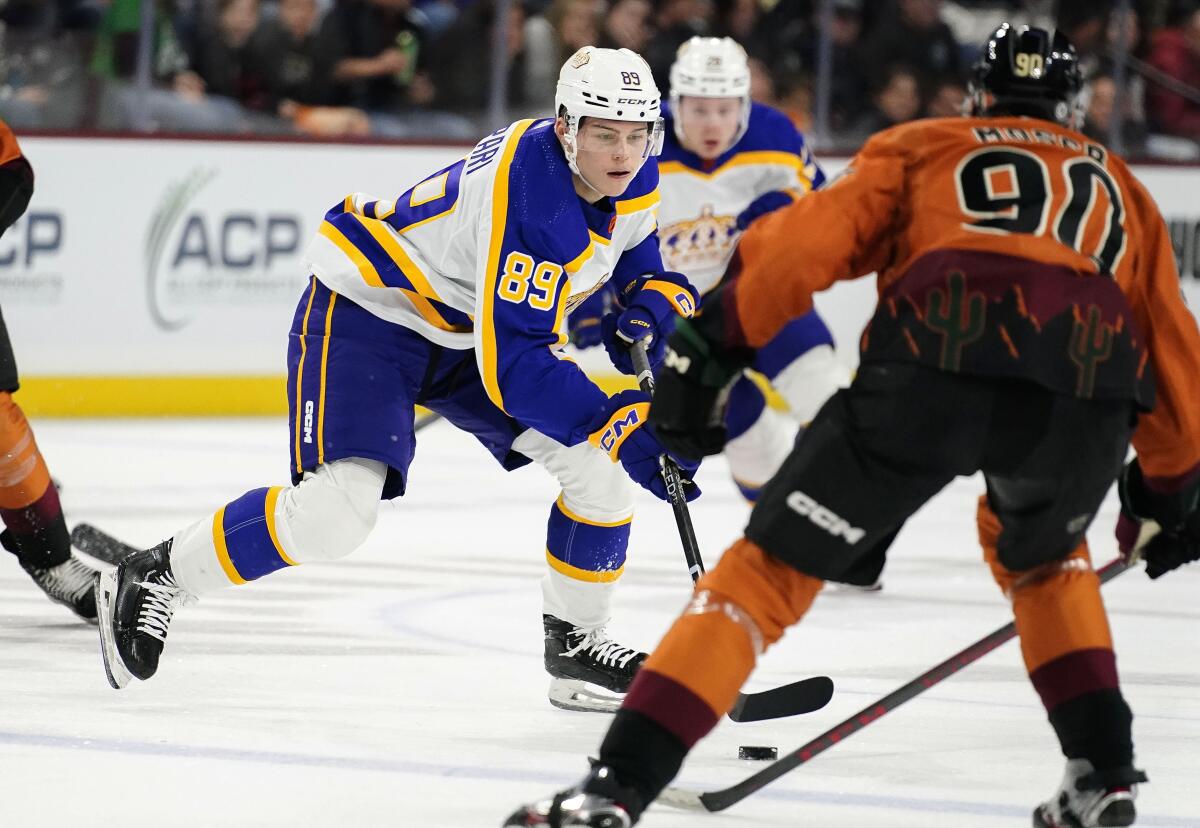 Kings forward Rasmus Kupari controls the puck in front of Coyotes defenseman J.J. Moser.