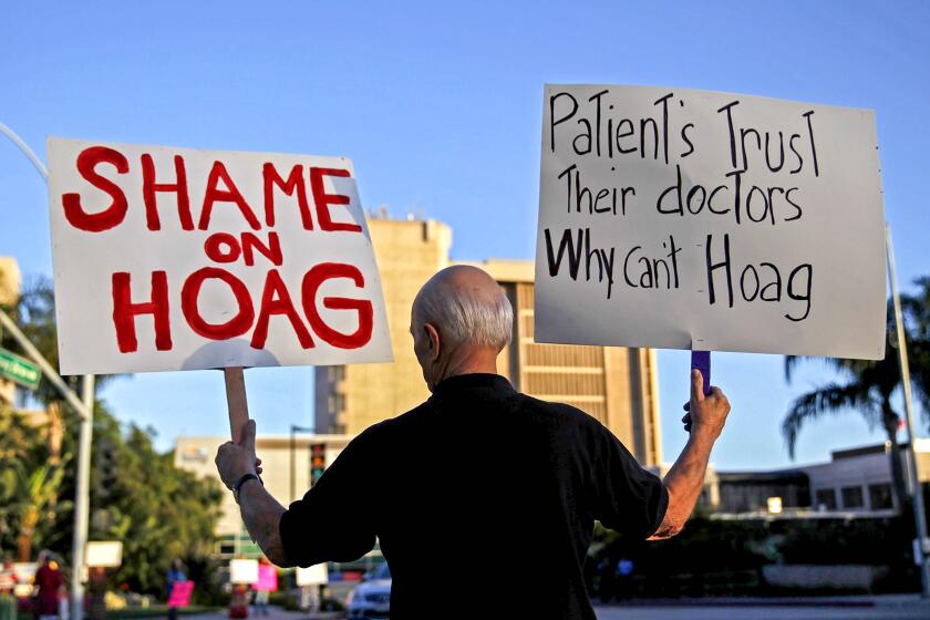 An abortion-rights advocate protests healthcare restrictions at Hoag Memorial Hospital in June 2013. 