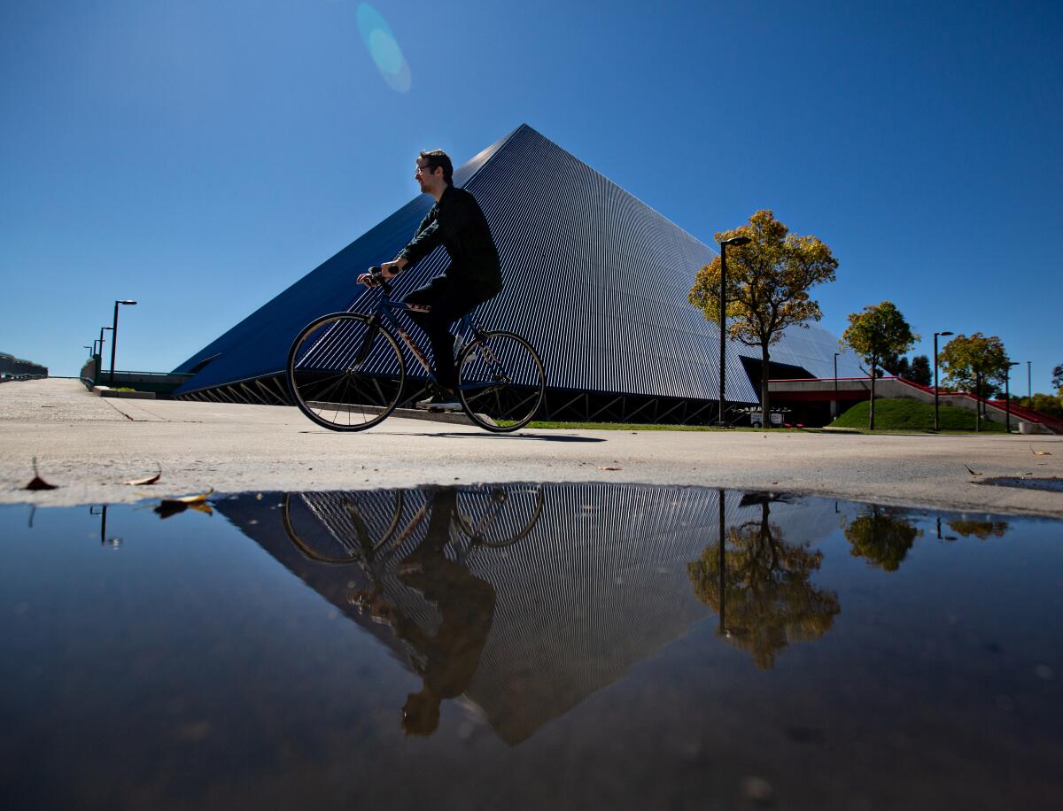 A student bikes past the Walter Pyramid at Cal State Long Beach. This fall, the vast majority of CSU classes will be online only.