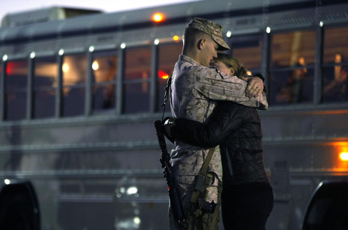 A young Marine and his wife embrace moments before the sunrise departure of the 1st Marine Expeditionary Force from Camp Pendleton on Monday.