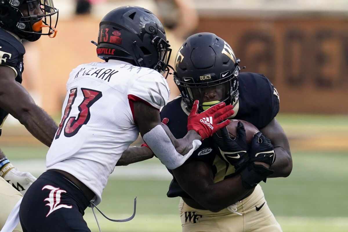 Wake Forest running back Justice Ellison is tackled by Louisville defensive back Kei'Trel Clark during the second half of an NCAA college football game on Saturday, Oct. 2, 2021, in Winston-Salem, N.C. (AP Photo/Chris Carlson)