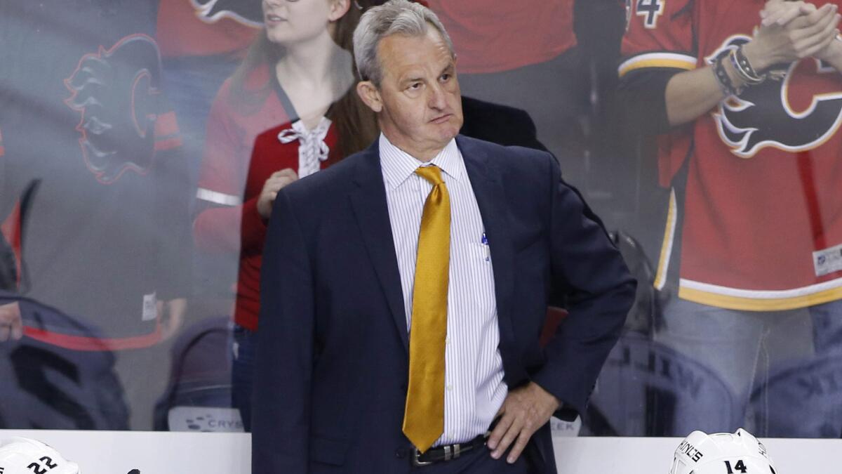 Kings Coach Darryl Sutter stands behind the bench during a loss to the Calgary Flames on Thursday.