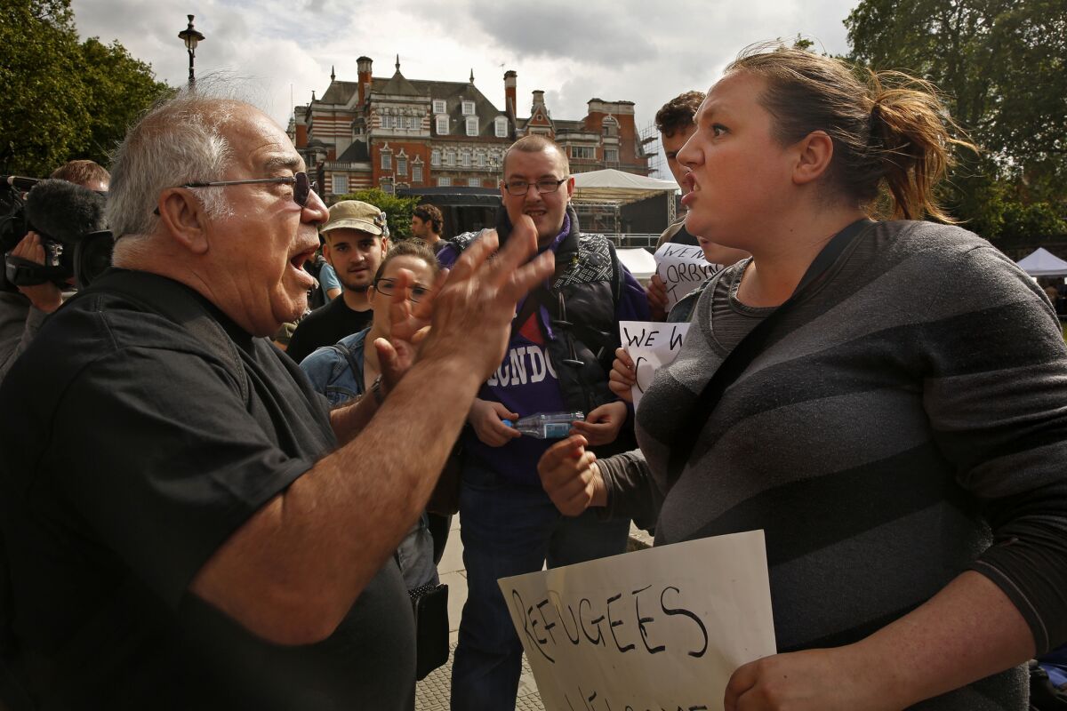Cara Rose, right, argues over the issue of migrants and immigration with a man on the sidewalk across the street from Parliament in London. Tensions ran high after the historic vote to leave the European Union.