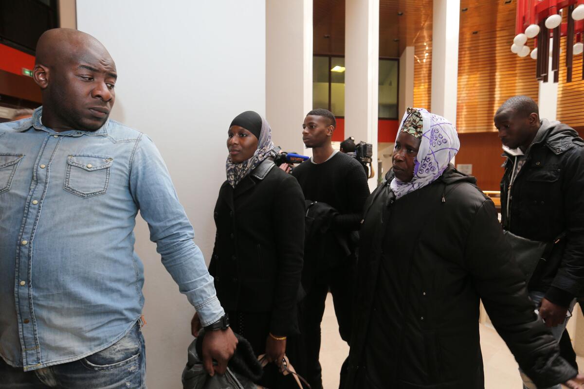 Relatives of Bouna Troare -- brother Siyakha Traore, left, sister Aissatou, center, and mother Tokhonte -- arrive at the Rennes courtroom in western France where two police members went on trial March 16 over the deaths of two teens, including Troare.