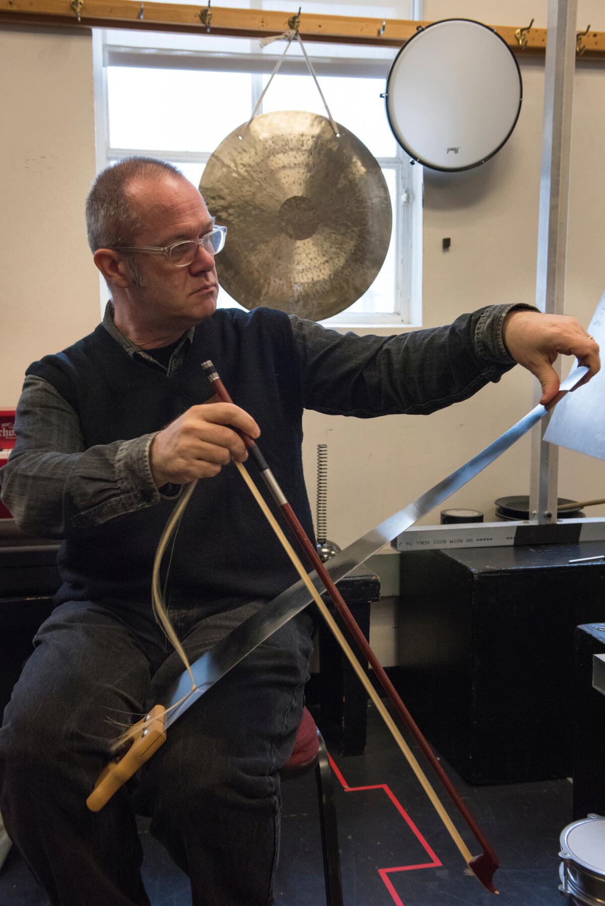 Composer David Coulter at rehearsal playing the saw. (Stefan Cohen)