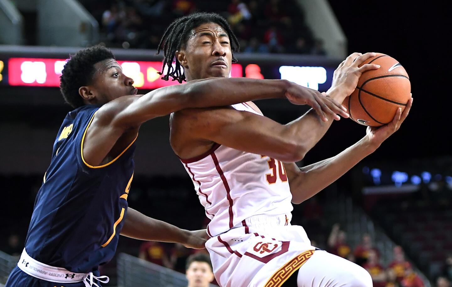 USC guard Elijah Stewart is fouled by Cal guard Darius McNeill while driving to the basket on Jan. 28.
