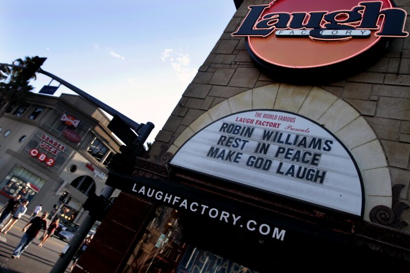 Tourists walk past the Laugh Factory on Sunset Boulevard, where the marquee pays tribute to Robin Williams.