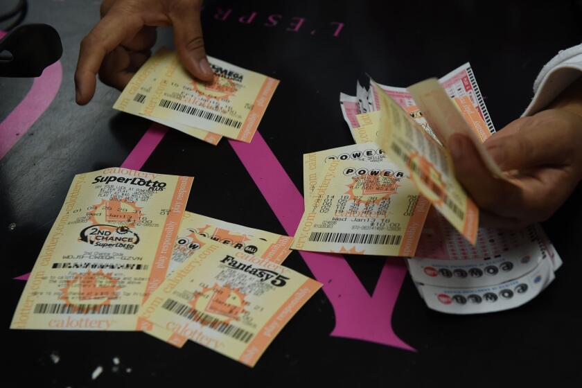 A customer picks up her California Powerball lottery tickets at the famous Bluebird Liquor store in Hawthorne.