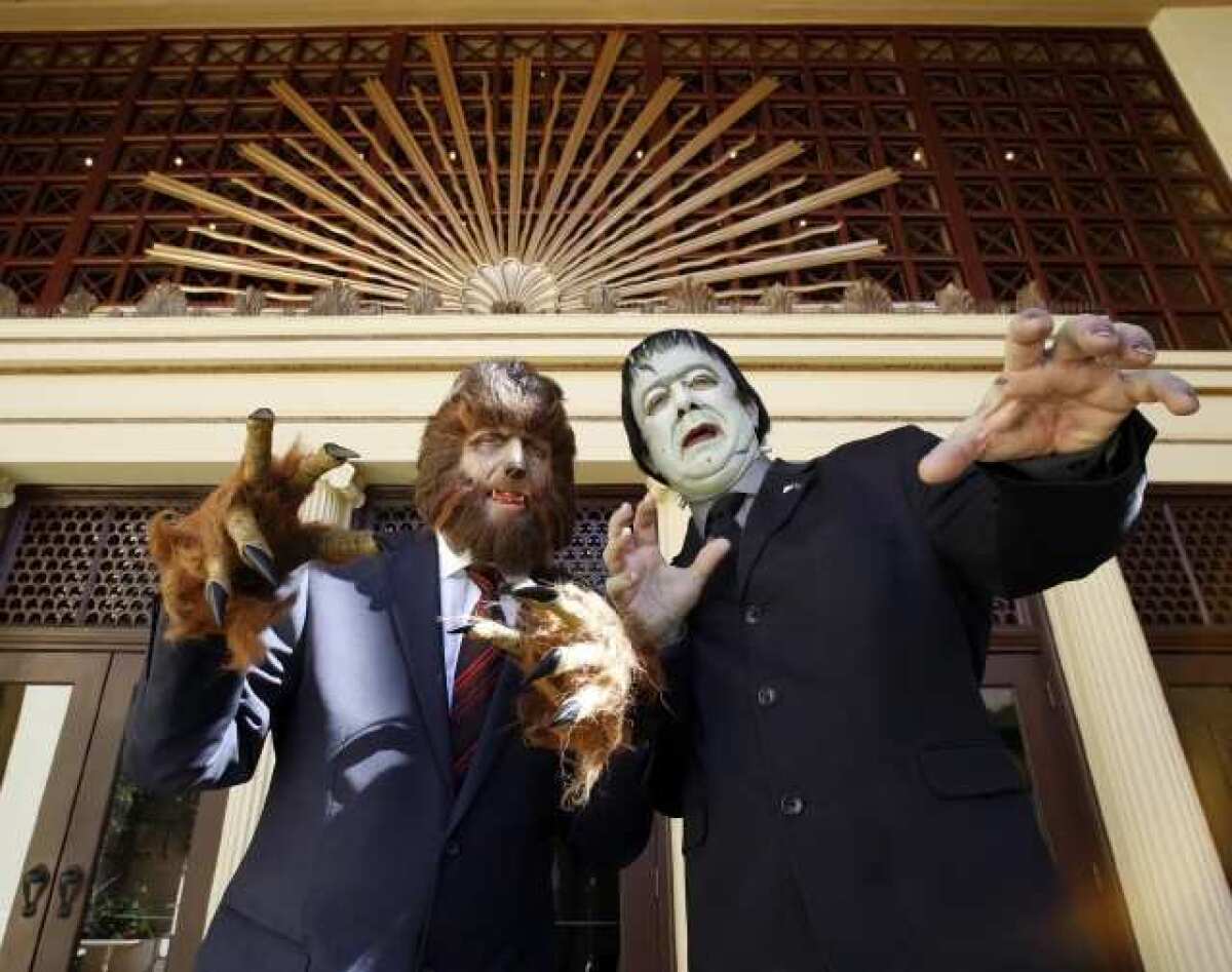 The Wolf Man, left, and Frankenstein, right, pose for some pictures at their mock presidential debate before the screening of Frankenstein Meets the Wolf Man at the Alex Theater in Glendale.