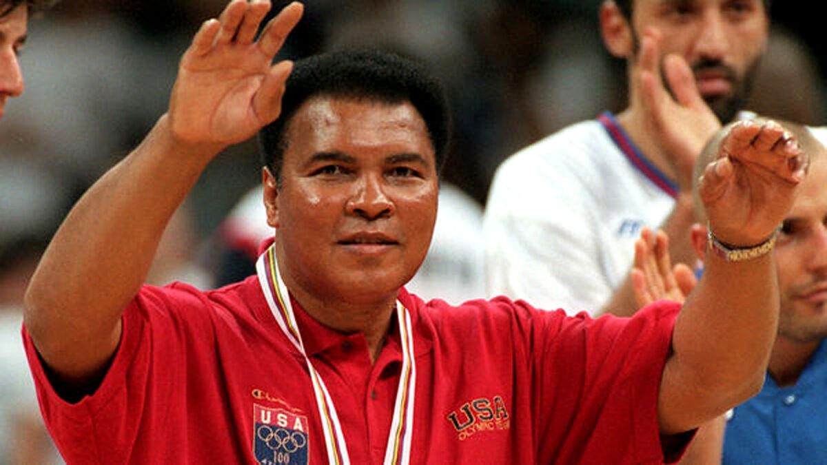Muhammad Ali acknowledges the cheers of the crowd during halftime of the gold-medal basketball game between the United States and Yugoslavia at the Atlanta Olympic Games on Aug. 3, 1996.